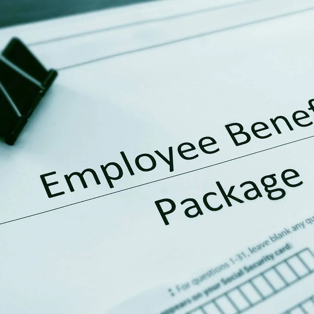 Close-up of an employee benefits package document held with a binder clip